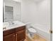 Bright bathroom with white tile, a vanity with a marble countertop, and a tub shower combo at 8073 S Albion St, Centennial, CO 80122