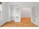 Versatile bonus room with hardwood floors, a built-in shelving unit, and an open doorway to another room at 8073 S Albion St, Centennial, CO 80122