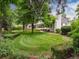 Expansive backyard featuring a lush lawn, mature trees, manicured hedges, and a glimpse of the home's rear at 3975 S Cherry St, Cherry Hills Village, CO 80113