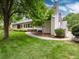 Expansive backyard featuring a lush lawn, mature trees, manicured hedges, and a glimpse of the home's rear at 3975 S Cherry St, Cherry Hills Village, CO 80113