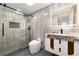 Modern bathroom featuring gray tile, a glass-enclosed shower, and a stylish white vanity with gold accents at 3975 S Cherry St, Cherry Hills Village, CO 80113