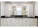 Bright bathroom with double sinks, black countertops and custom white cabinetry at 3975 S Cherry St, Cherry Hills Village, CO 80113