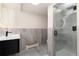 Modern bathroom featuring grey tile, floating vanity, large shower, and circular backlit mirror at 3975 S Cherry St, Cherry Hills Village, CO 80113