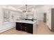Bright kitchen featuring a large island with sink, custom cabinets, modern lighting, and large windows at 3975 S Cherry St, Cherry Hills Village, CO 80113