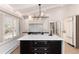 Bright kitchen featuring a large island with sink, custom cabinets, modern lighting, and stainless steel appliances at 3975 S Cherry St, Cherry Hills Village, CO 80113