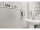 Bathroom featuring a pedestal sink, mirror, and a gallery wall of framed prints at 16762 Tejon Ln, Broomfield, CO 80023