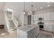 Open kitchen showcases a large center island, stainless appliances, and easy access to the staircase at 16762 Tejon Ln, Broomfield, CO 80023
