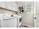 Functional laundry room features white cabinets and modern appliances with a neutral color scheme at 16762 Tejon Ln, Broomfield, CO 80023