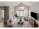 Open-concept living room with cathedral ceiling, large windows, and an elegant chandelier at 16762 Tejon Ln, Broomfield, CO 80023