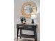 Stylish black console table with gold handles, a stylish lamp and plants at 7700 W Glasgow Pl # 10A, Littleton, CO 80128