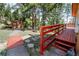 A scenic backyard with a red railing and stone walkway leading to a shed, surrounded by lush trees at 8624 S Doubleheader Ranch Rd, Morrison, CO 80465