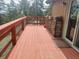 Spacious wooden deck featuring wood pile and views of surrounding trees and partial mountain view at 8624 S Doubleheader Ranch Rd, Morrison, CO 80465