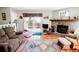Cozy living room featuring a stone fireplace, wood floors, and a sliding glass door to deck at 8624 S Doubleheader Ranch Rd, Morrison, CO 80465