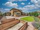Spacious backyard featuring a patio, well-maintained lawn, garden beds, and beautiful landscaping at 784 Sweet Pine Ct, Monument, CO 80132