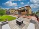 Well-manicured backyard featuring a patio, fire pit area, and lush landscaping at 784 Sweet Pine Ct, Monument, CO 80132