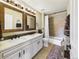 Well-lit bathroom featuring a double vanity, decorative mirrors and a shower-tub combo at 784 Sweet Pine Ct, Monument, CO 80132