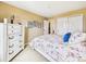 Bright bedroom featuring a floral-patterned bed, white furniture, tan walls and a closet at 784 Sweet Pine Ct, Monument, CO 80132