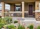 Inviting front porch features detailed railing, stone accents, and manicured landscaping enhancing the home's curb appeal at 784 Sweet Pine Ct, Monument, CO 80132