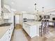 Open kitchen features a large center island, hardwood floors, stainless appliances, and barstool seating at 784 Sweet Pine Ct, Monument, CO 80132
