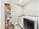 Functional laundry room featuring a washer, dryer, shelving and beige walls at 784 Sweet Pine Ct, Monument, CO 80132