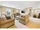 Bright living room featuring comfortable sofas, a modern coffee table, and scenic views from large windows at 784 Sweet Pine Ct, Monument, CO 80132