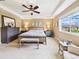 Serene main bedroom with tray ceiling, ceiling fan, and a large window offering outdoor views at 784 Sweet Pine Ct, Monument, CO 80132