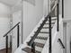 Modern staircase with sleek, black railings and white risers, offering a contemporary design at 20789 E Princeton Pl, Aurora, CO 80013