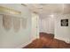 Basement entry area with wood floors, decorative macrame and doorway to white painted rooms and doors at 10957 Bryant St, Westminster, CO 80234