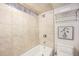 Cozy bathroom featuring a tiled shower-tub and a wall-mounted towel rack at 10957 Bryant St, Westminster, CO 80234