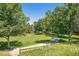 Scenic landscape featuring a lush green lawn, mature trees, and a paved path at 10957 Bryant St, Westminster, CO 80234