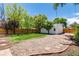 Lush backyard with fence, trees, and gravel area with a detached garage adding character and privacy at 4197 S Grant St, Englewood, CO 80113