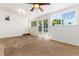 Bedroom with carpet, white walls, ceiling fan, windows, and glass patio doors leading to backyard at 4197 S Grant St, Englewood, CO 80113