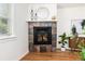 A charming fireplace with a stone surround, wooden mantle, and decor adds warmth to the living space at 4197 S Grant St, Englewood, CO 80113