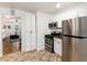 Efficient kitchen featuring stainless steel appliances, white cabinets and neutral tile flooring at 4197 S Grant St, Englewood, CO 80113