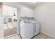 Laundry room featuring a white washer and dryer with white cabinets and tile floors at 4197 S Grant St, Englewood, CO 80113