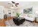 Bright living room featuring hardwood floors, a ceiling fan, and a comfortable sofa with decorative pillows at 4197 S Grant St, Englewood, CO 80113