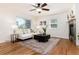Bright living room features hardwood floors, a ceiling fan, and a stone fireplace at 4197 S Grant St, Englewood, CO 80113
