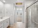 Bathroom view showcasing double vanity with chrome fixtures, shower, and decorative ceiling feature at 14451 Pansy Loop, Morrison, CO 80465
