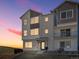 Modern townhome featuring a brick facade and charming balcony, set against a colorful sunset at 14451 Pansy Loop, Morrison, CO 80465