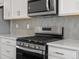 Close up of the kitchen range and oven with stainless steel backsplash and countertops at 14451 Pansy Loop, Morrison, CO 80465