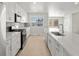 Open kitchen with large island, stainless steel appliances, and modern white cabinetry at 14451 Pansy Loop, Morrison, CO 80465