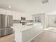 Modern kitchen featuring stainless steel appliances, white cabinets, and a large island with quartz countertops at 14451 Pansy Loop, Morrison, CO 80465