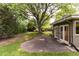 Secluded backyard featuring a stone patio and lush green lawn with mature trees and landscaping at 2934 S Columbine St, Denver, CO 80210