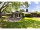 Green backyard featuring a stone patio and lush green lawn with mature trees and landscaping at 2934 S Columbine St, Denver, CO 80210