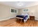 Bedroom featuring hardwood floors, two windows, a bench, and side table at 2934 S Columbine St, Denver, CO 80210