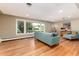 Bright living room featuring hardwood floors, large windows, and stylish blue mid-century modern furniture at 2934 S Columbine St, Denver, CO 80210