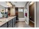 Bathroom with a granite vanity, shower/tub, a separate toilet area, and dark colored cabinets at 1480 Sterling Hill Ct, Castle Rock, CO 80104