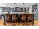 Kitchen with island and bar seating, complete with stainless steel appliances, custom cabinets and wood floors at 1480 Sterling Hill Ct, Castle Rock, CO 80104