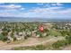 An aerial view showcases a neighborhood with homes, green spaces, and mountain views at 2043 Fendlebrush St, Highlands Ranch, CO 80129