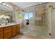 Bright bathroom with a glass shower, stone tile, a window, and updated fixtures at 2043 Fendlebrush St, Highlands Ranch, CO 80129
